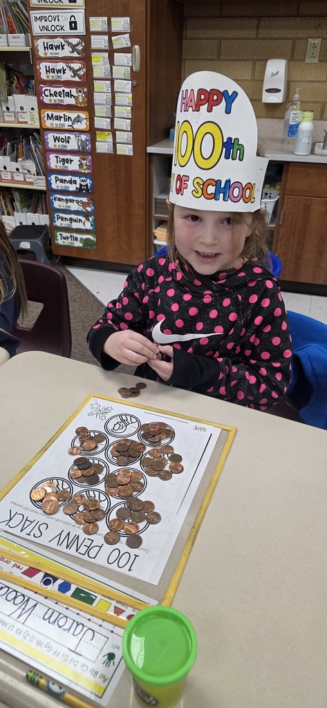 a young girl in a polka dotted sweatshirt and a 100s day crown