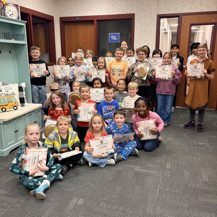 a group of approximately 35 students holding student of the month certificates and smiling