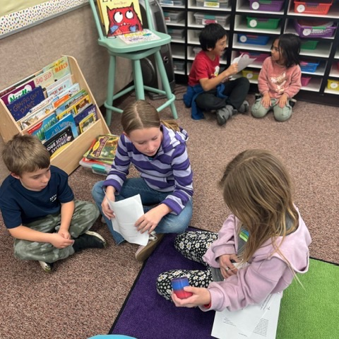Multiple 4th grade students reading to 1st grade students 