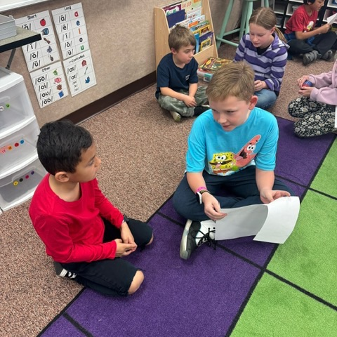 Multiple 4th grade students reading to 1st grade students 