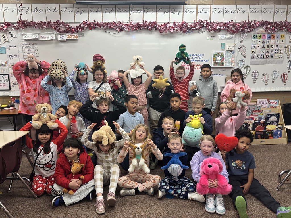 students posing in their pjs and and holding stuffed animals
