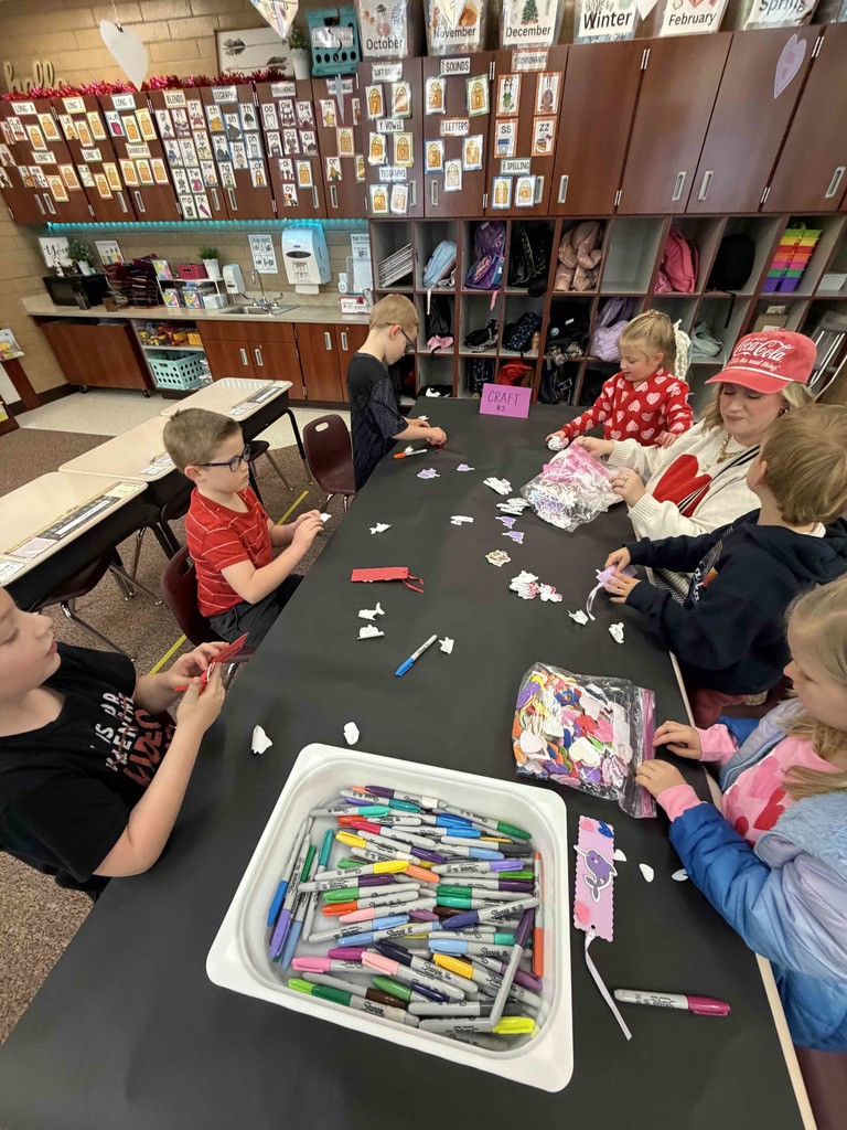 Students making a bookmark with a parent helper.