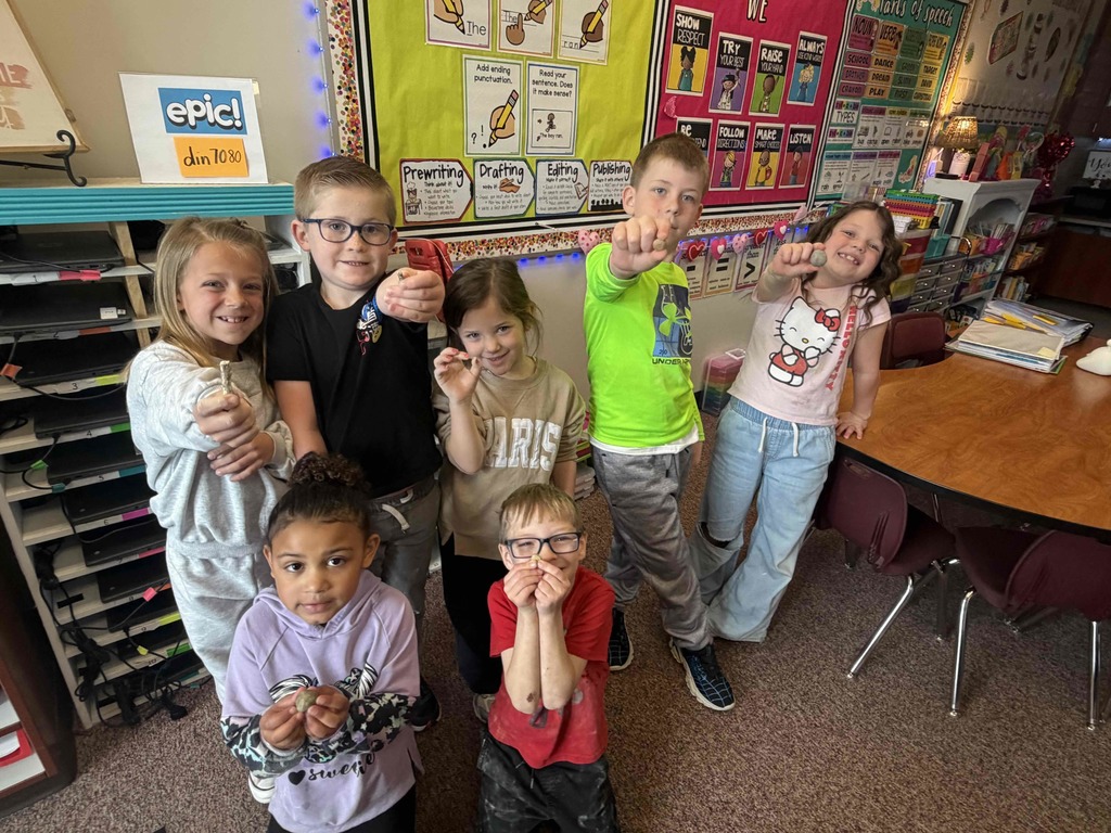 Students holding up different types of rocks.