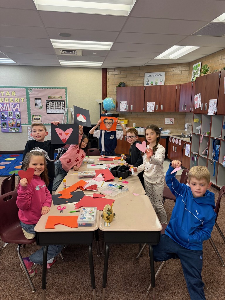 Second grade students making a Valentine's Day craft.