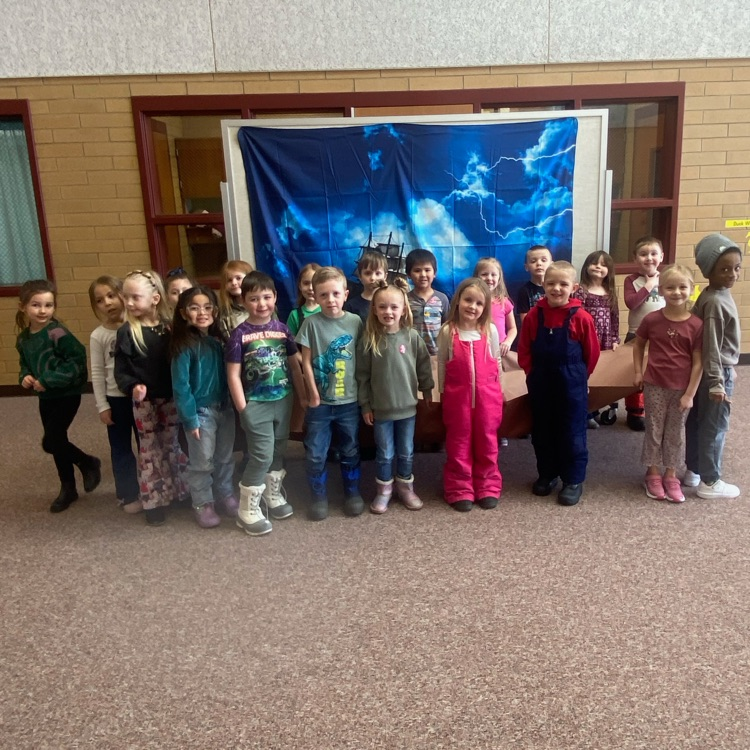 a group of students standing in front of an image with a ship in the ocean