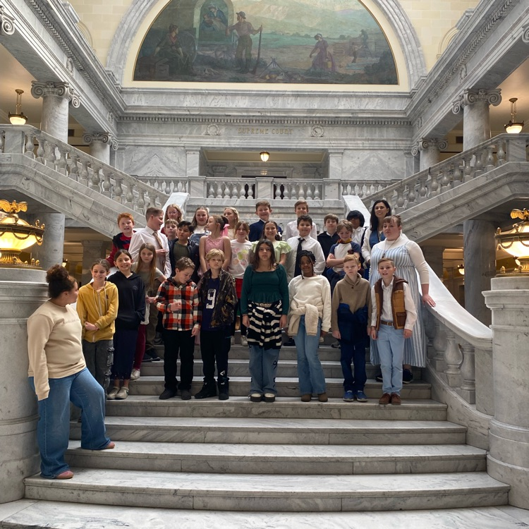 a class standing on the steps of the Utah state capitol 