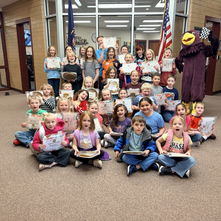a group of students holding certificates with a hawk mascot 