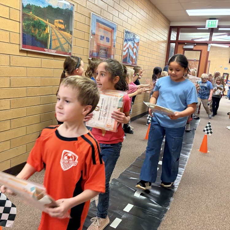 students of the month in a line while other kids cheer them on