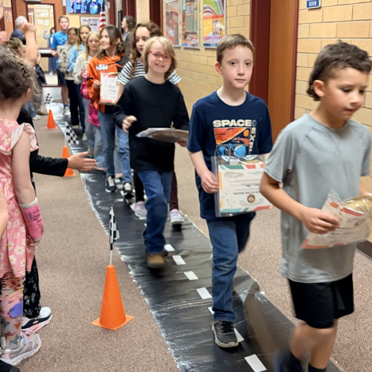 students of the month in a line while other kids cheer them on