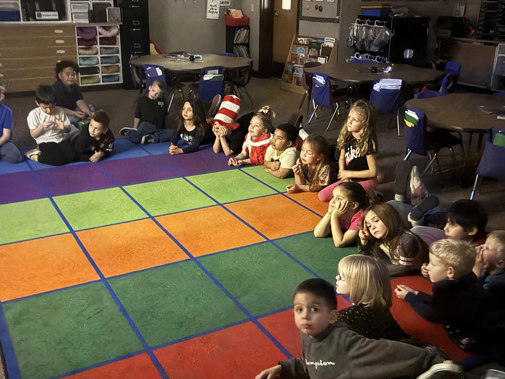 Kindergarten students listening to a read a loud from a Dr. Seuss book