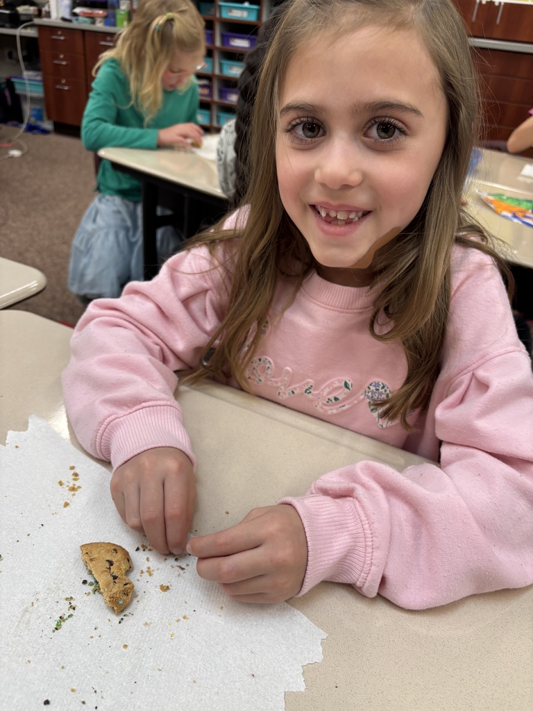 student posing with their cookie