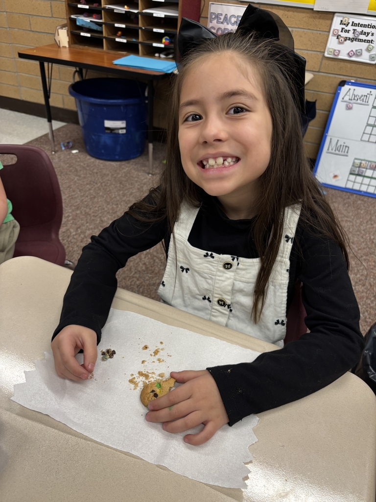 student posing with their cookie