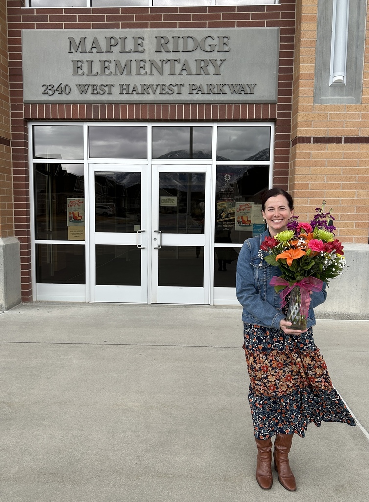 Sara Matis in front of Maple Ridge holding flowers.