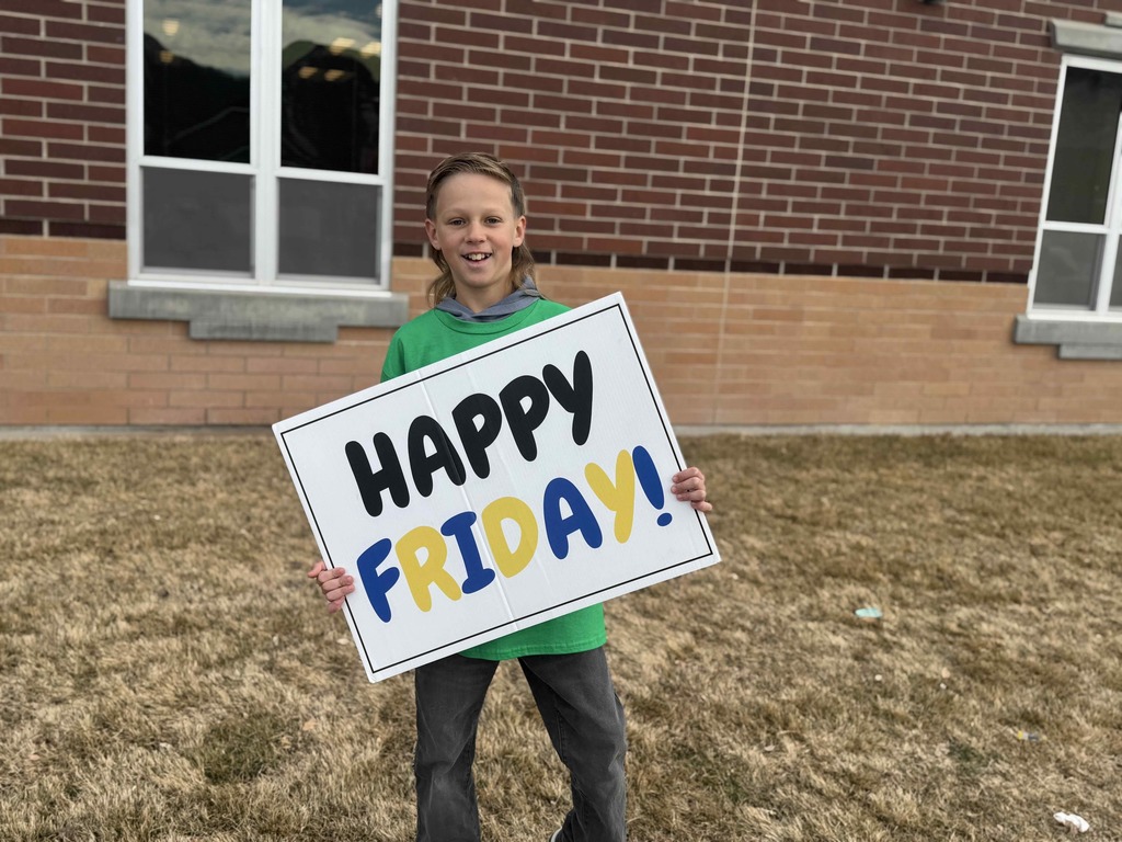 Student holding a sign that says: Happy Friday!