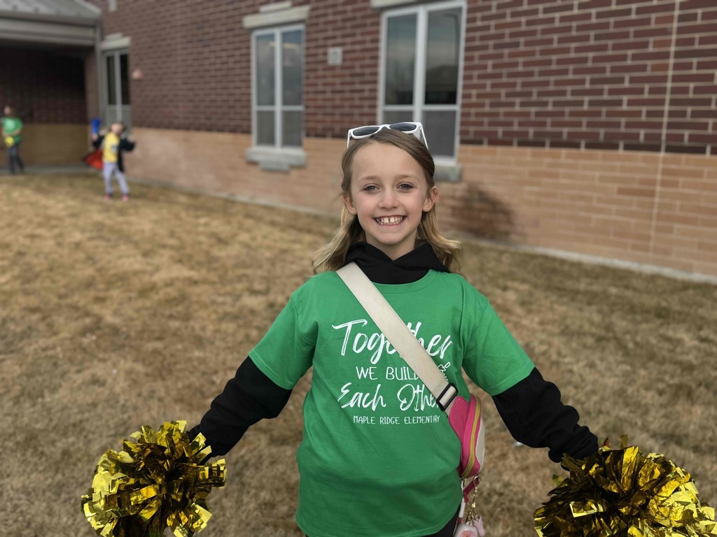 A student holding pom poms welcoming students to school.