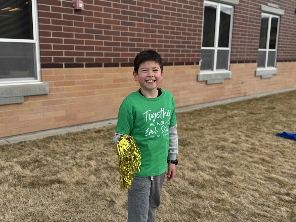 A student holding pom poms welcoming students to school.