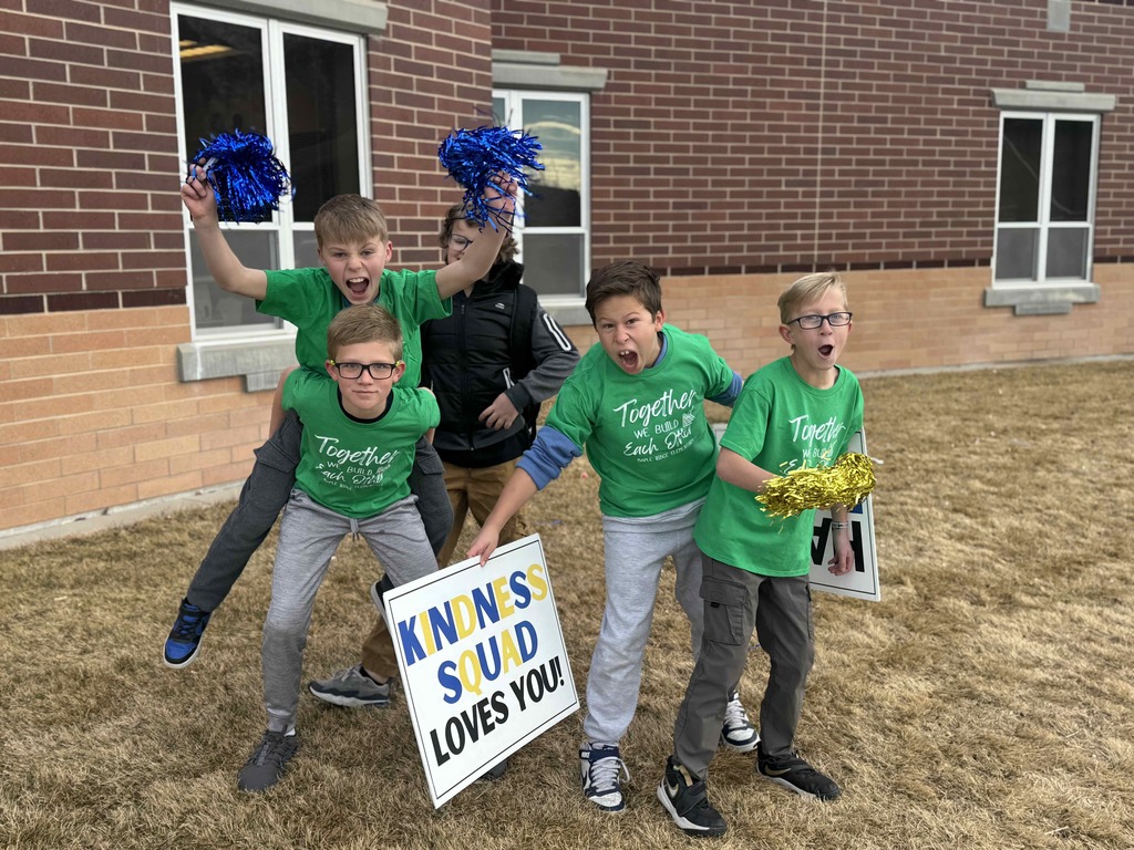 A group of students welcoming other students to school.