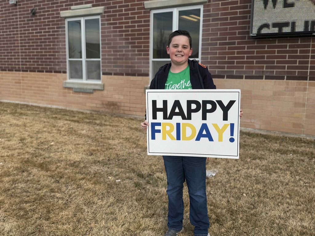 Student holding a sign that says: Happy Friday!