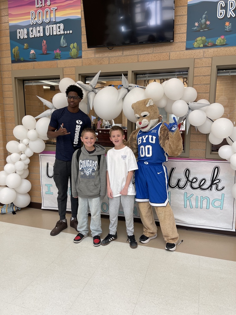 Cosmo and a BYU athlete posing with two students.