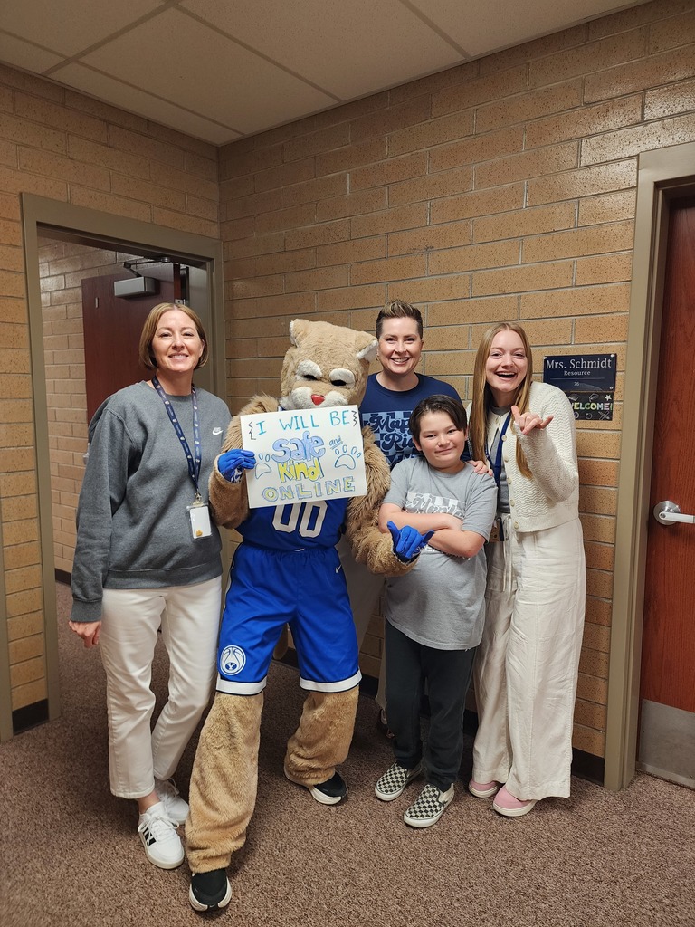 Cosmo posing with a student and three teachers.