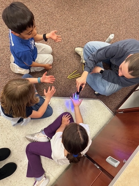 Students learning about germs from a UVU nursing student.
