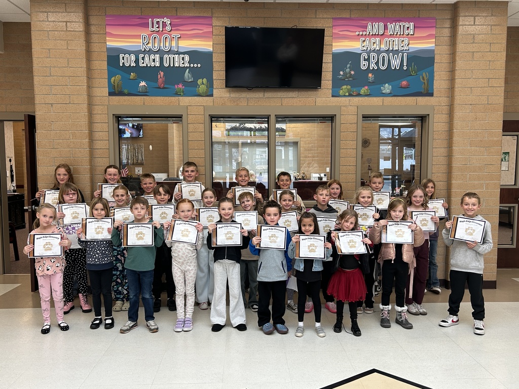 Students in the Maple Ridge foyer holding their Student of the Month certificates.