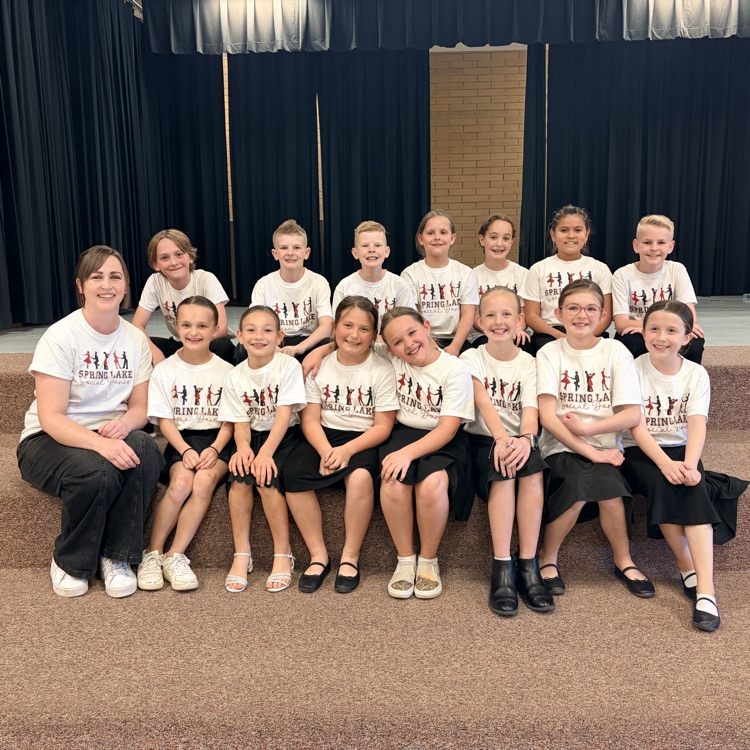 students sitting in two lines with their dance teacher