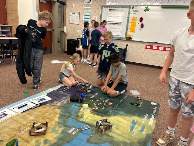 Students learning spheres on a map.