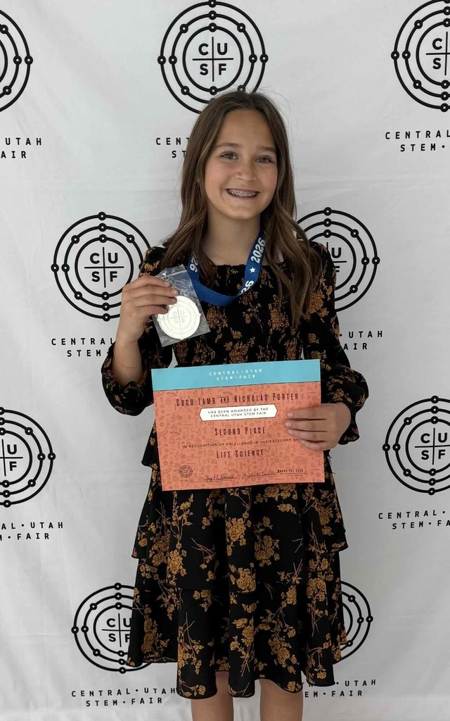 Coco Lamb holding up her science certificate and medal.