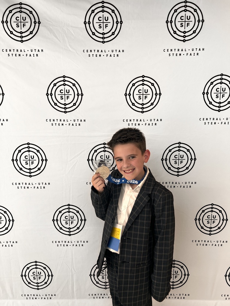 Nick Porter holding up his science fair medal.