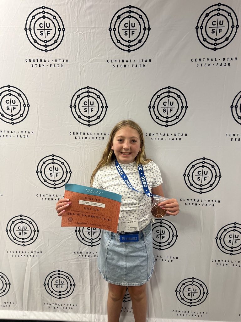 Vivian Hess holding up her science fair awards.