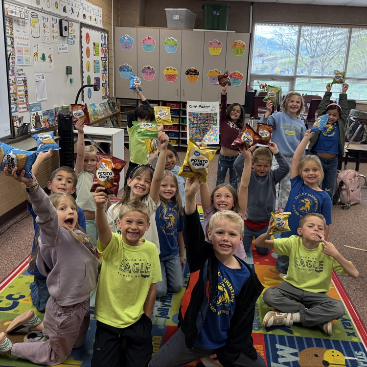 First Grade Students holding up their chip reward. 