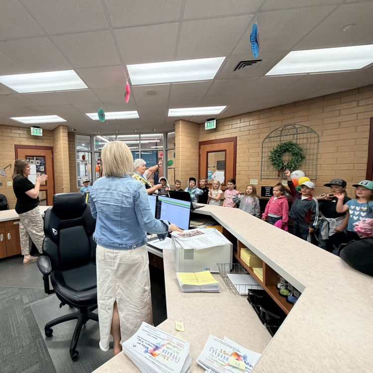 a first grade class singing to the secretaries 