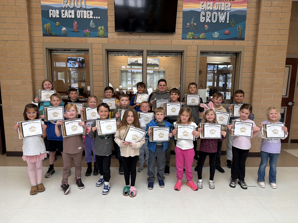 Students standing in the Maple Ridge foyer holding their student of the month certificates.