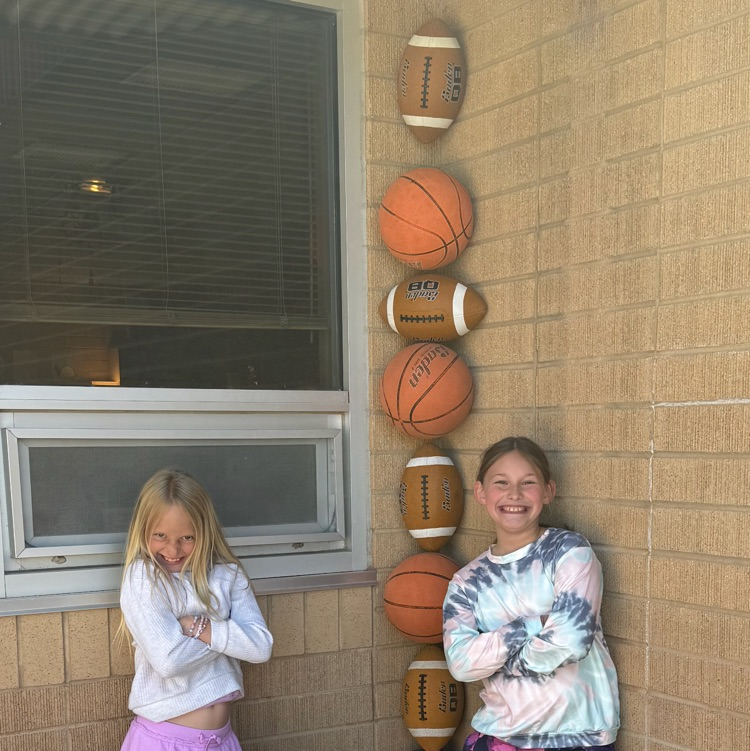 third grade students pose by balls stuck in corner.