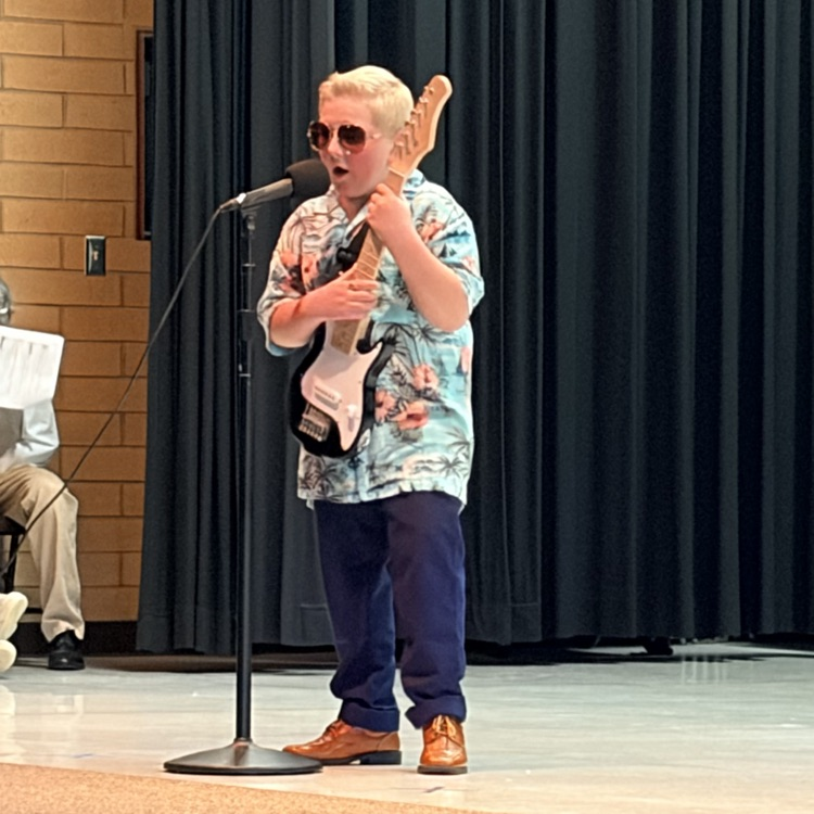 a student holding a guitar and singing