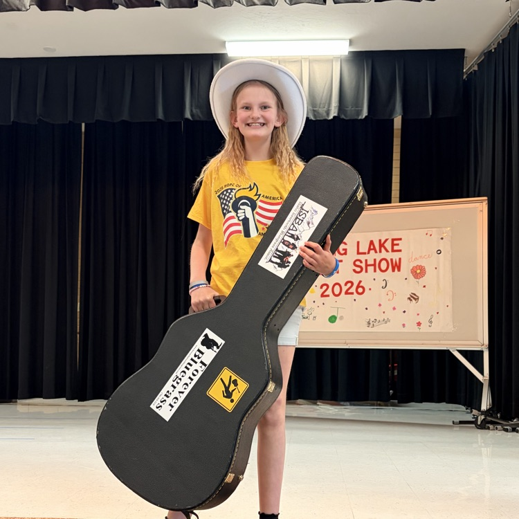 a student holding a guitar and smiling