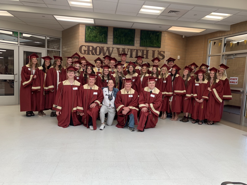 Mrs. Matis with former. Maple Ridge students in their caps and gowns.