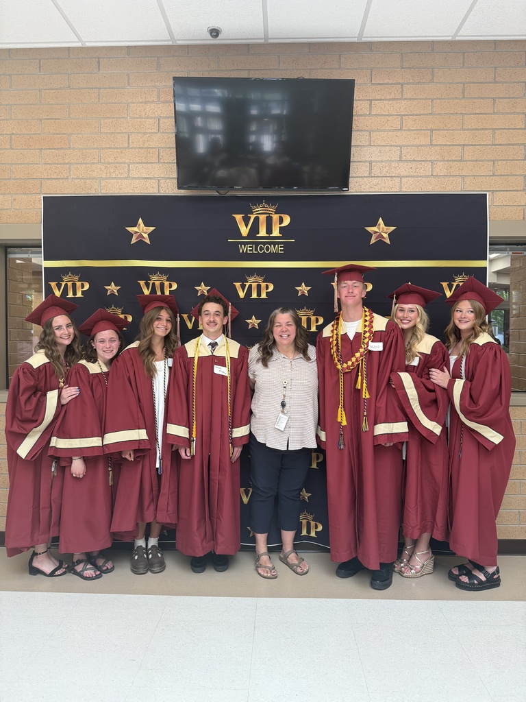 Mrs. Paynter with former students in their caps and gowns.