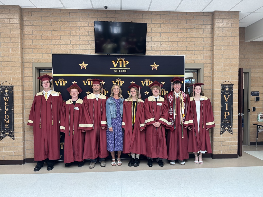 Mrs. Mathews with former students in their caps and gowns.
