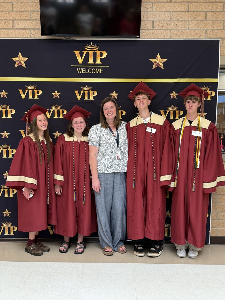 Mrs. Manning with former students in their caps and gowns.