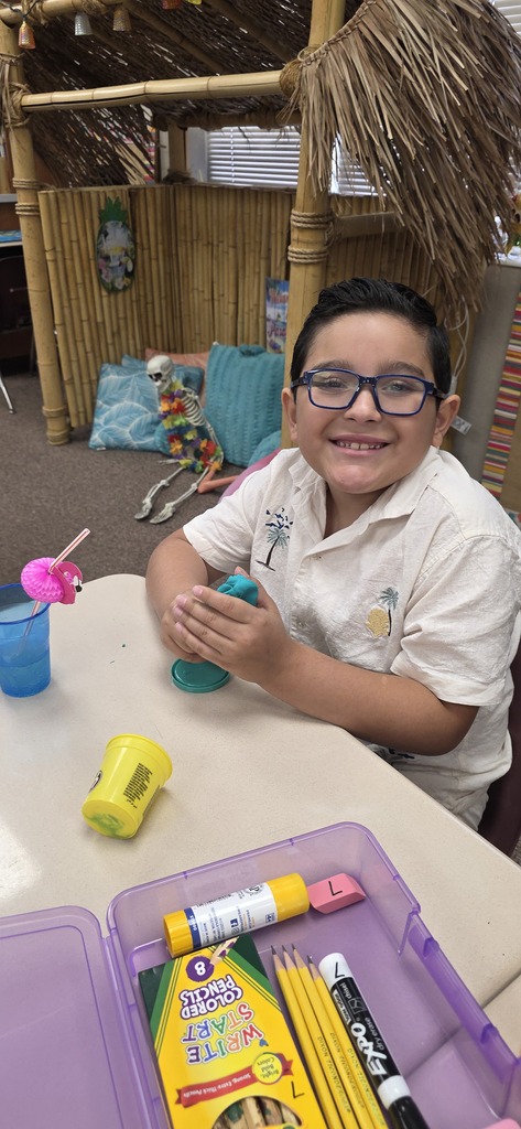 a second grader making a play dough creation