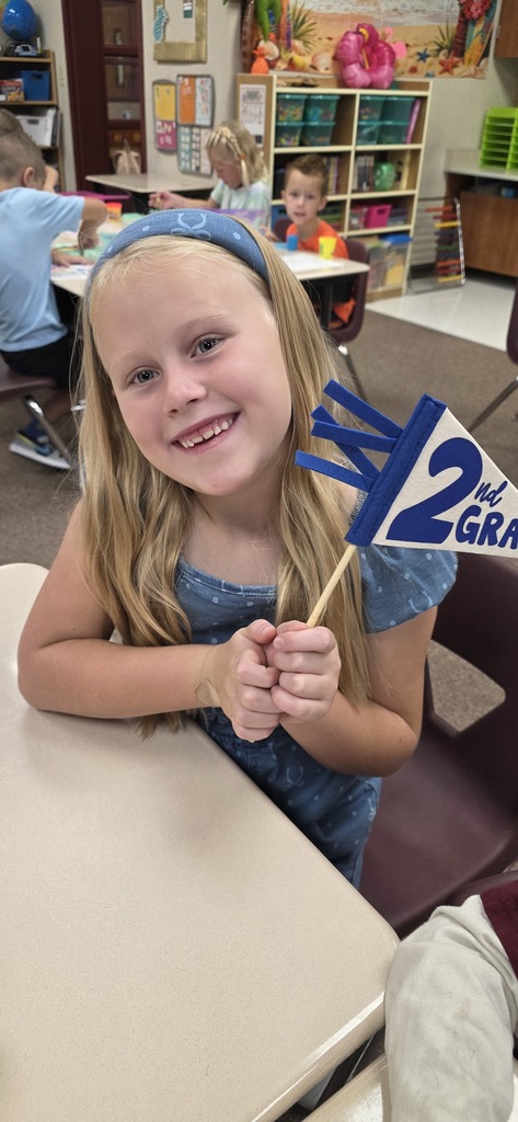 a second grader holding a 2nd grade pennant