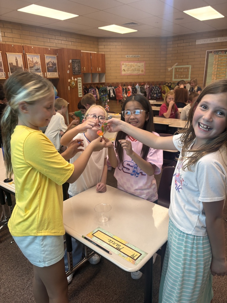 Kids holding their gummy worm and smiling