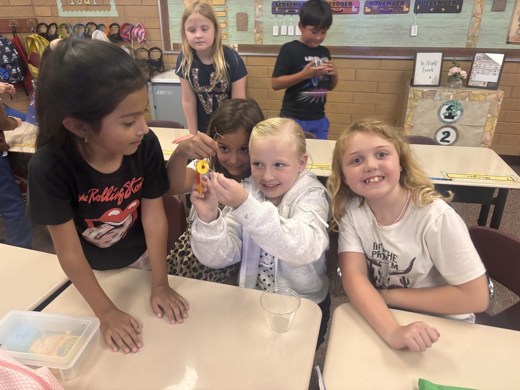 Kids holding their gummy worm and smiling