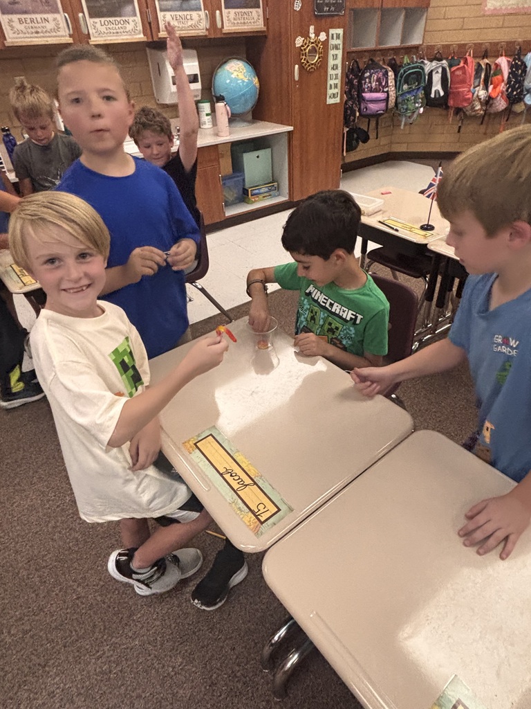 Kids holding their gummy worm and smiling