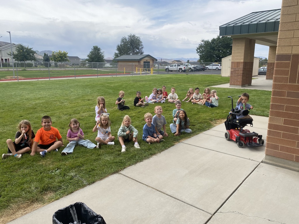 Mrs. McFarland's class eating popsicles on the grass