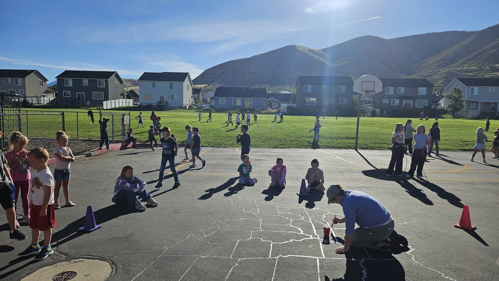 a volunteer painting the map on the blacktop