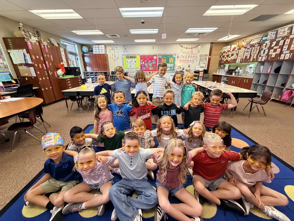 tudents sitting in a first grade classroom wearing gold.