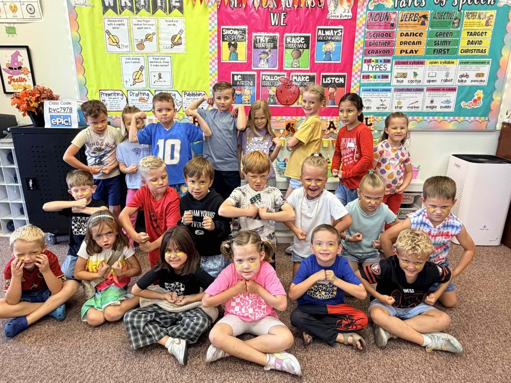 tudents sitting in a first grade classroom wearing gold.